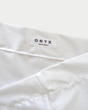 Funda satén blanca by ONYX. Foto en en estudio detalle etiqueta. Hecha en Uruguay. Slow fashion brand.