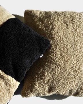 Dos almohadones sherpa CHECK by ONYX. Foto en estudio, lado liso en color beige y el otro con el lado a cuadros beige y negro.