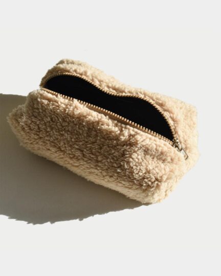 Neceser beige Sherpa fotografiado en estudio abierto.
