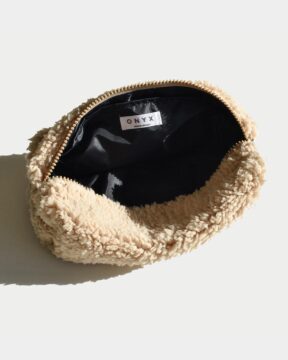 Neceser beige modelo Sherpa fotografiado en estudio. Estructura liviana con forro impermeable y bolsillo interno.