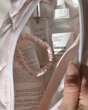 Neceser rosa Stripe fotografiado con zoom en interior con productos.
